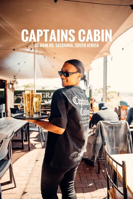 Captain's Cabin server carrying a tray of cold beers across the deck