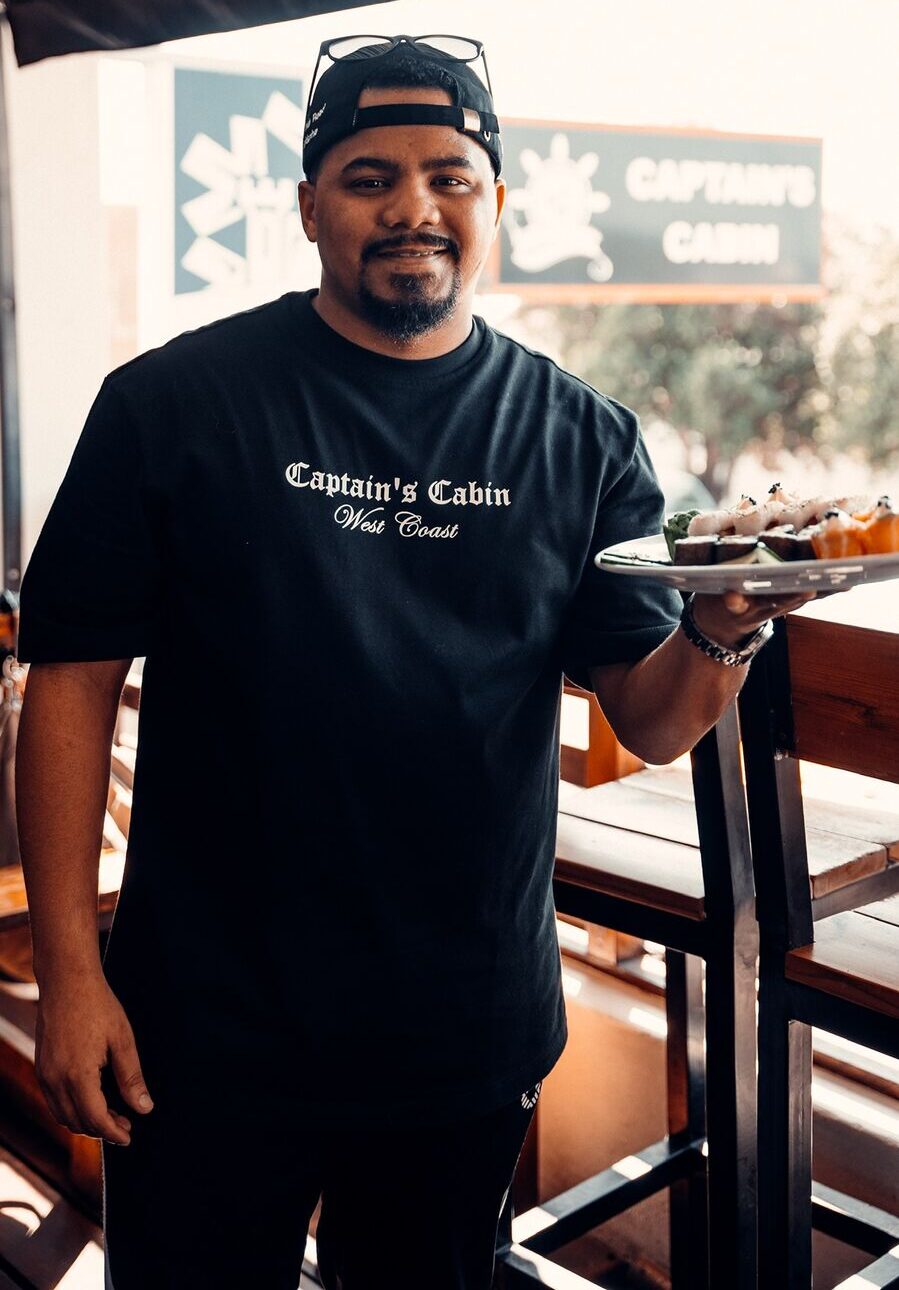 Server carrying a platter of fresh sushi at Captain's Cabin