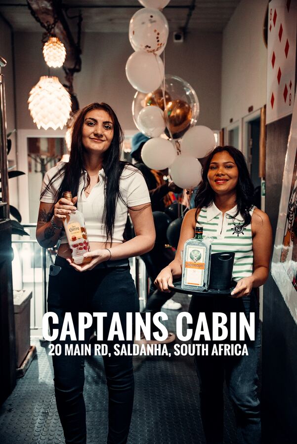 Two Captain's Cabin servers bringing bottles to a celebration